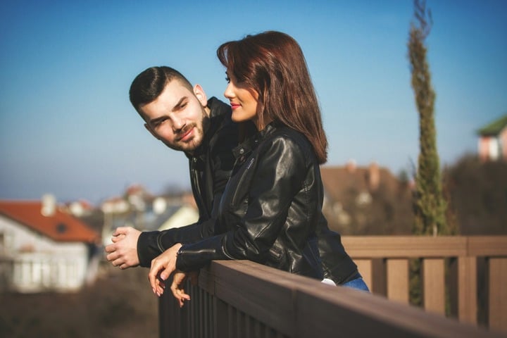 Un cuplu privește de pe balcon.
